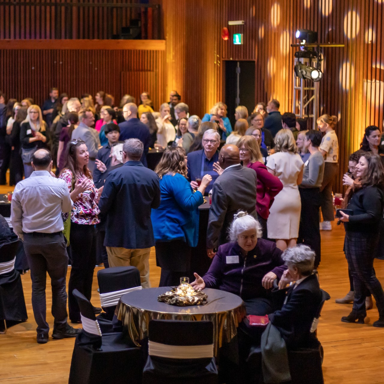 a large event room with  crowd of people