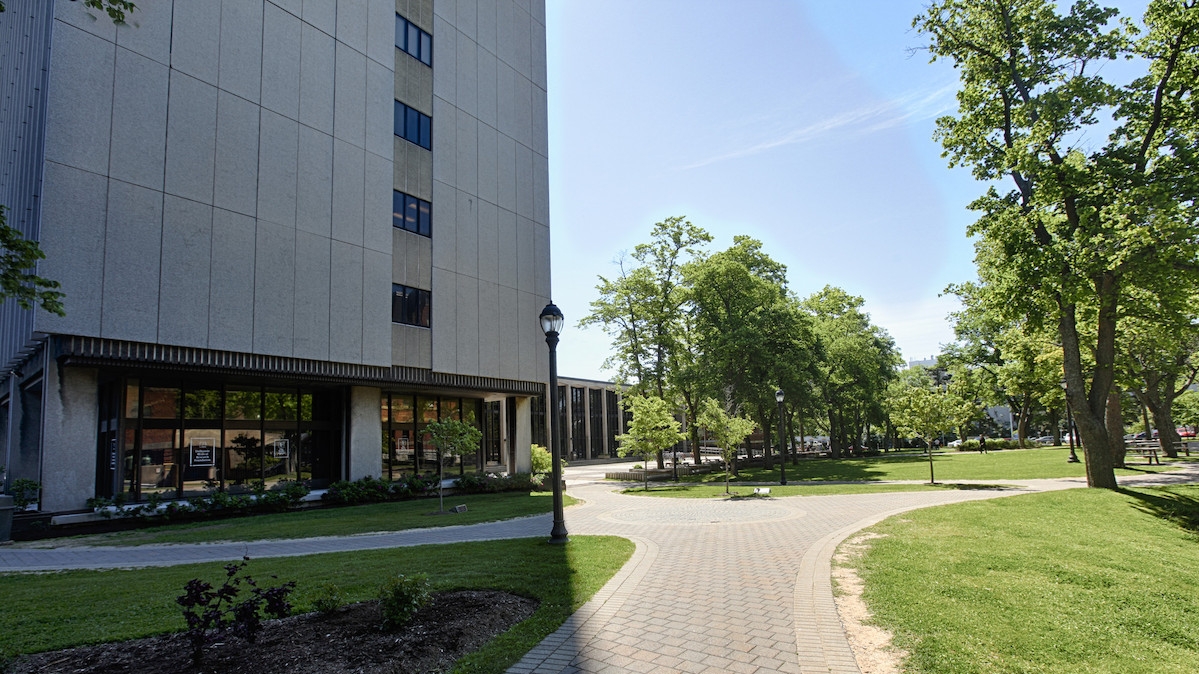 A stone pathway winds through the Carleton Campus quad next to the Sir Charles Tupper Medical Building.