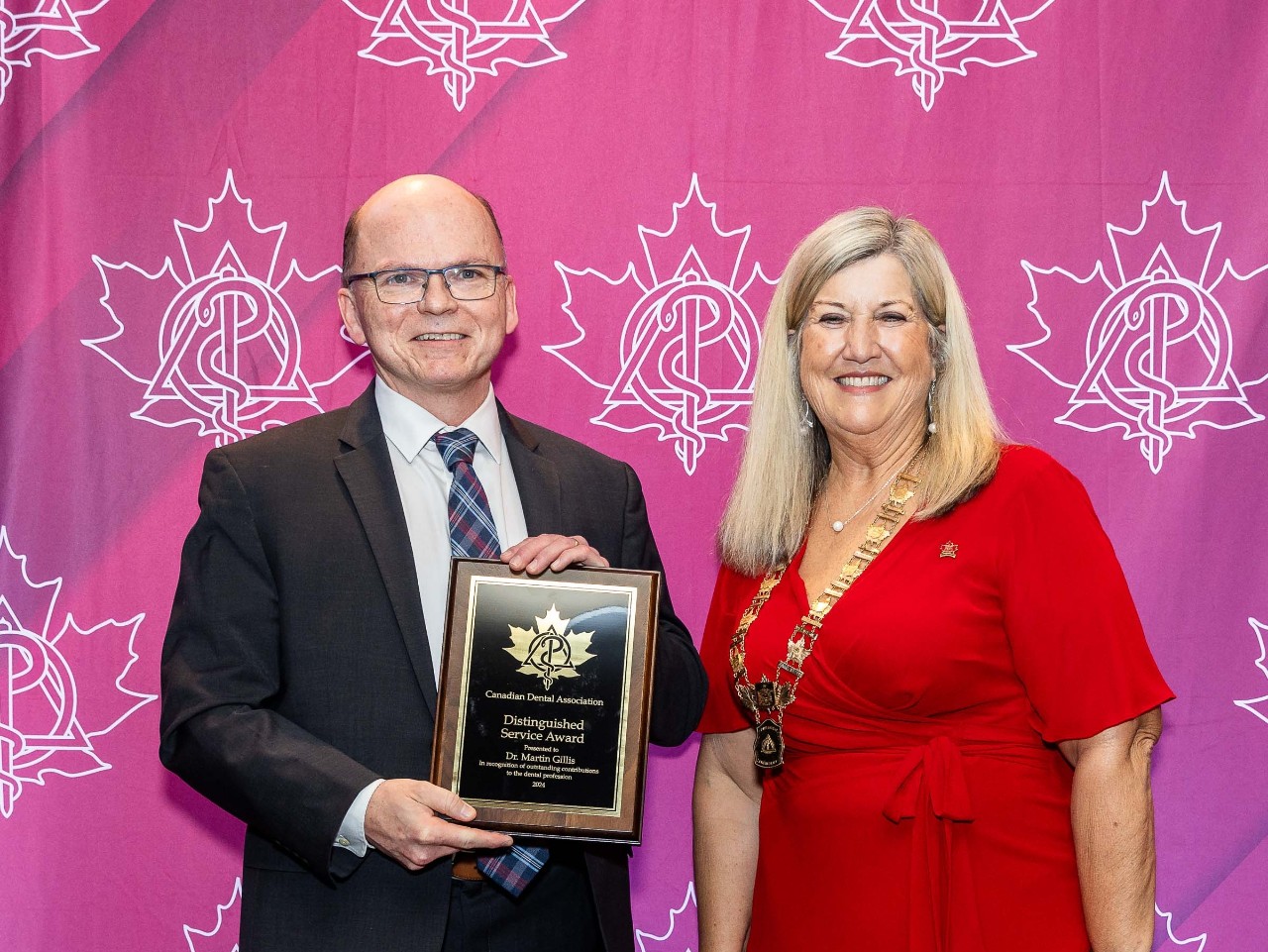 Gillis posing with his award at the event alongside another guest.