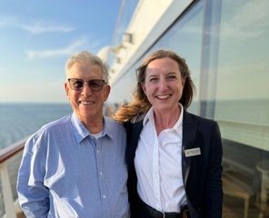 A couple standing on the deck of a cruise ship