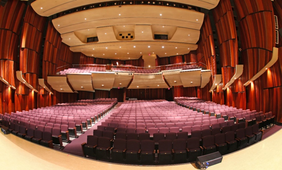 Empty auditorium with red walls and seats.