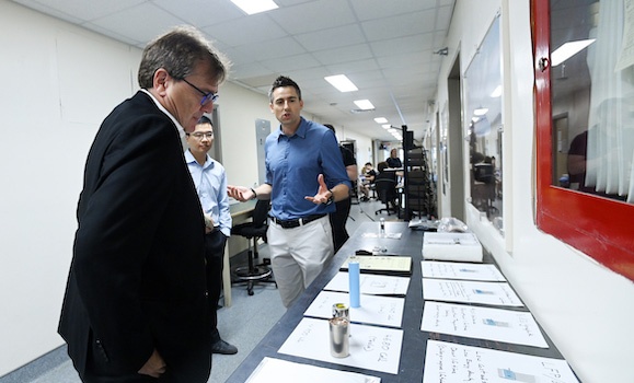 Drs. Michael Metzger and Chongyin Yang discuss battery research with Minister Wilkinson. 
