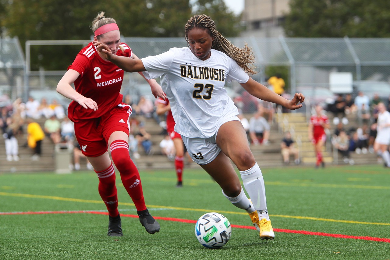 Womens soccer player running away from opponent