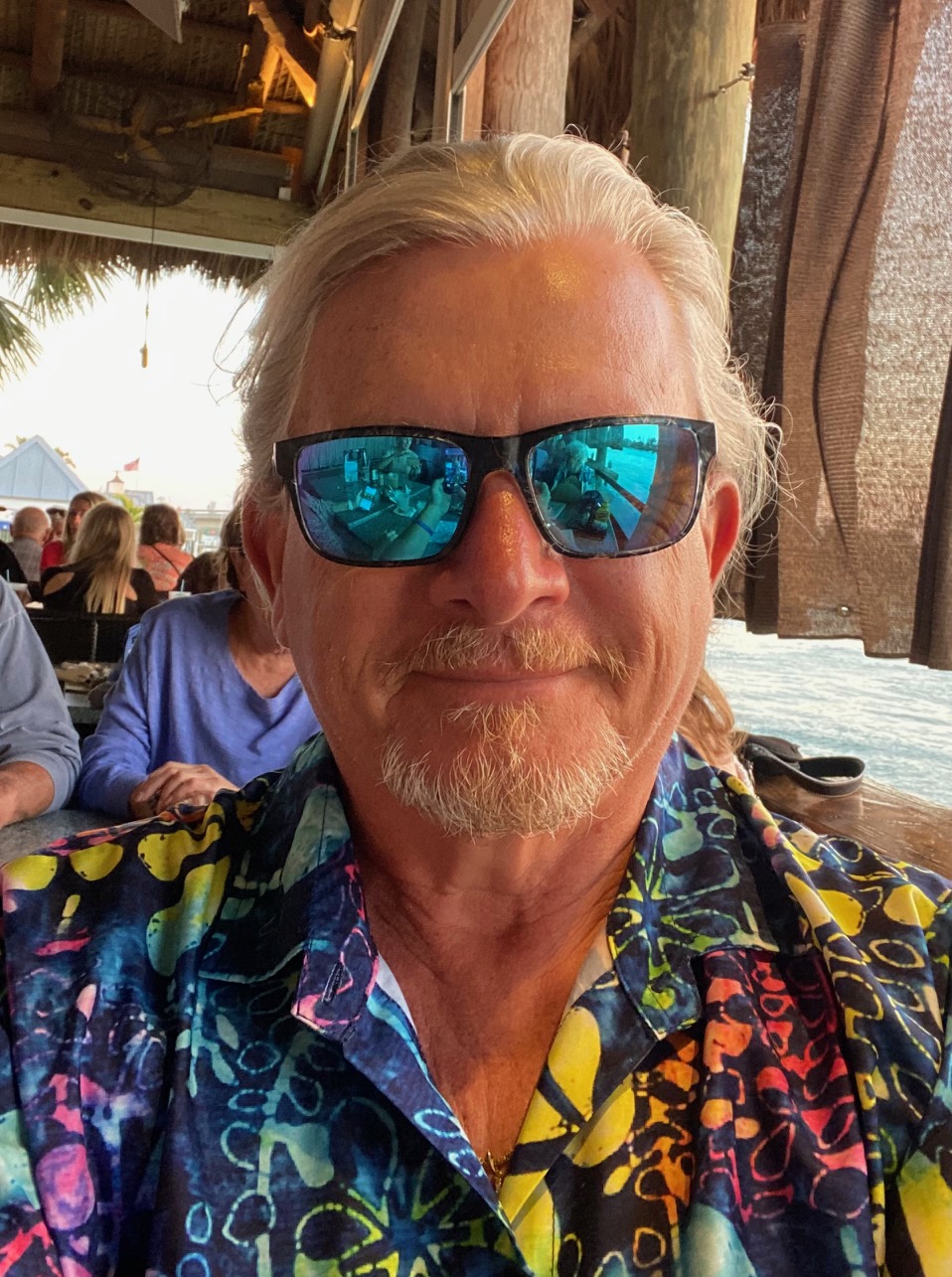  Douglas Evans portrait in a tropical setting wearing sunglasses.