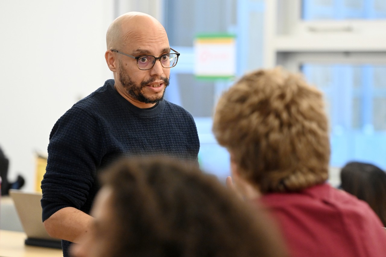 Dr. Whitfield is speaking to a student while teaching a class.