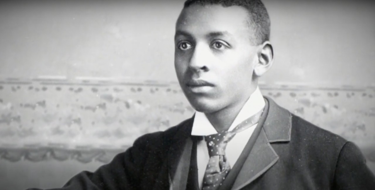 Historical image of a young Black man wearing a suit and tie.