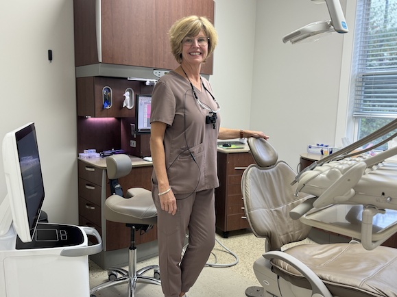 Blakey standing, smiling in a dental exam room.