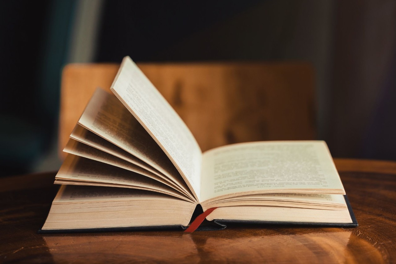 An open book sitting on top of a wooden table