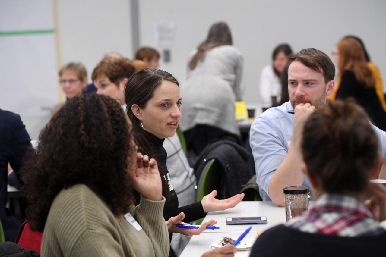 A group of Dal staff sit at a table mid-discussion.