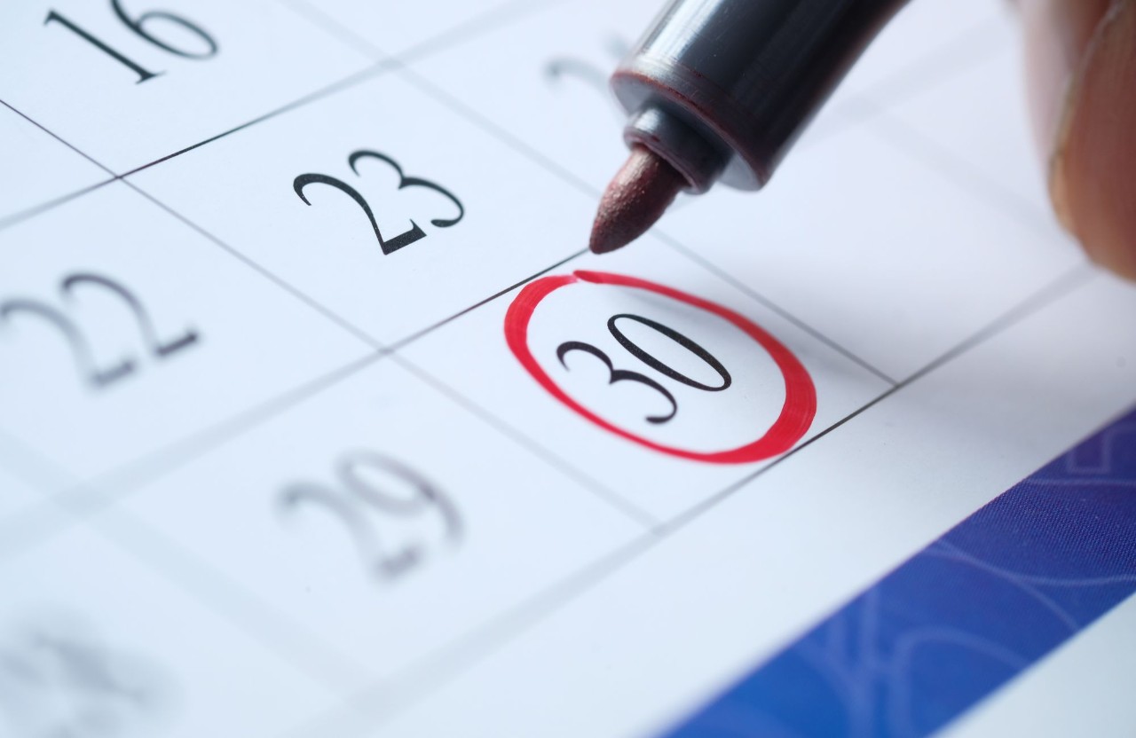 The date 30 is circled in red marker on a monthly calendar.