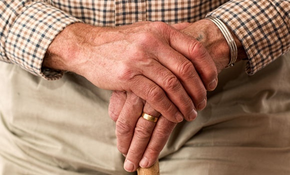 senior man hands clasped at his front