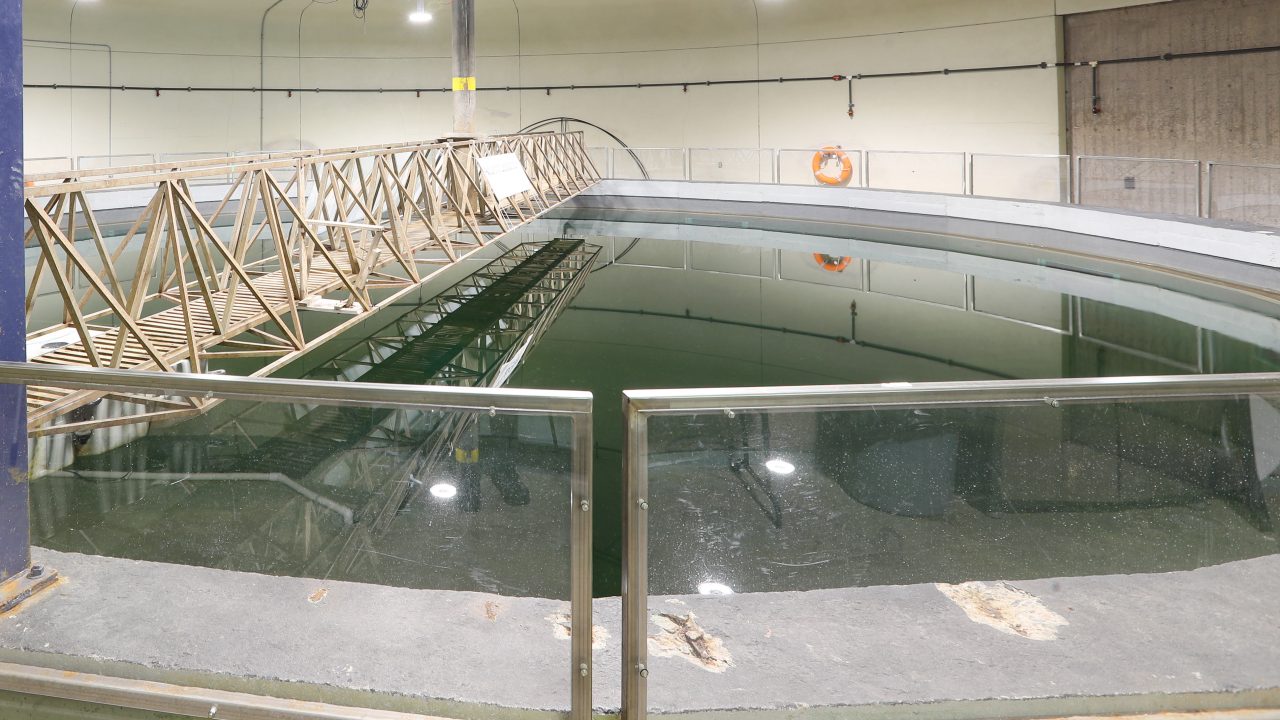 Aquatron facility's water tank, featuring a circular design with a metal bridge overhead