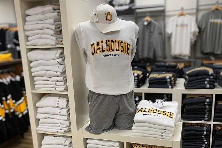 Shelves of Dalhousie merchandise with a mannequin wearing a sweatshirt that says Dalhousie and a baseball cap. 