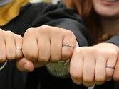 The hands of 4 alumni with outstretched arms showing their engineering iron rings. 