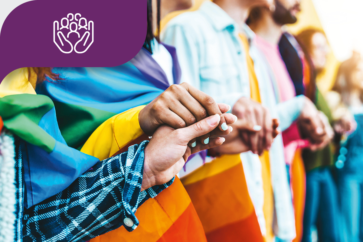 Diverse group holding hands with rainbow flags