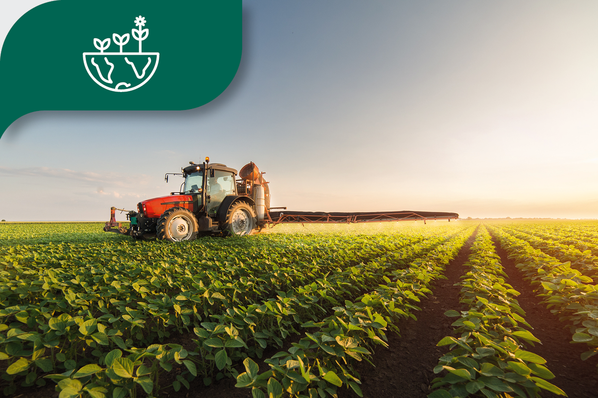 Tractor in a green field under a clear sky, illustrating sustainable agriculture research.