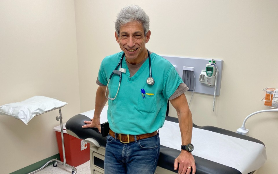 Gary Ernest smiling while leaning against an exam table in a clinic.