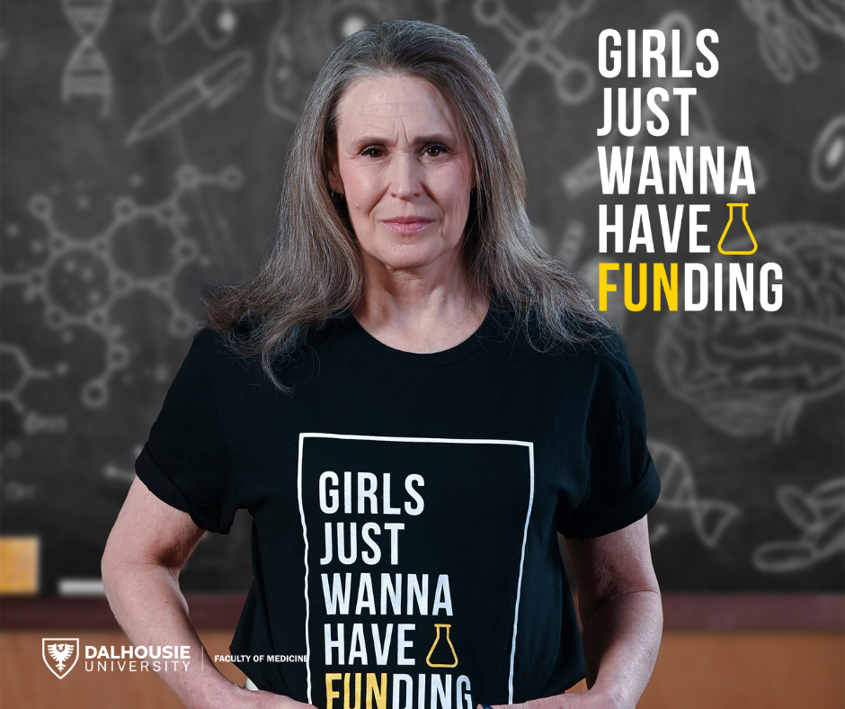 Eileen Denovan-Wright smiling slightly wearing a "Girls Just Wanna Have Funding" black t-shirt.