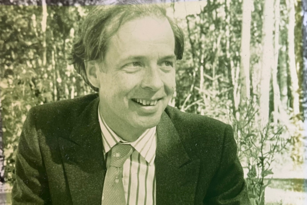 A black and white photo of a man wearing a suit and tie