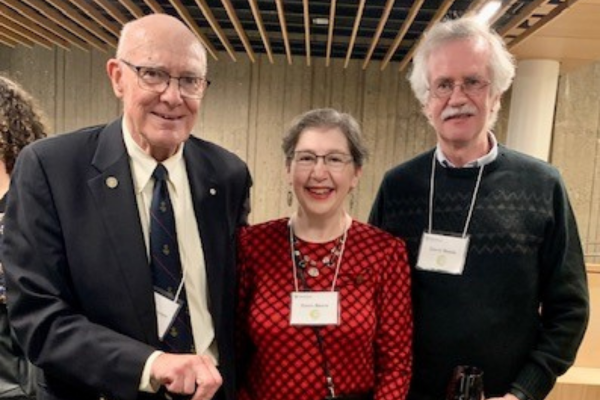 A group of three people standing together wearing name tags